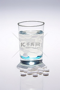 白色表面玻璃杯中的药丸和水