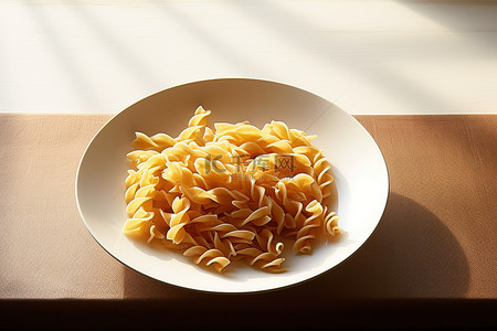 厨房桌子上的白盘里的新鲜意大利面