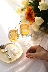 一对夫妇在桌子上放着香槟，手里拿着订婚戒指和鲜花