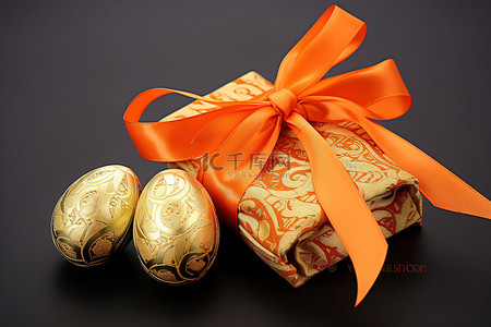 小金色背景图片_橙色丝带中的小金色包装纸包裹着一个鸡蛋