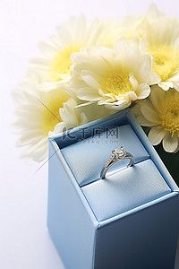 盒子里背景图片_订婚戒指装在蓝色盒子里，上面有鲜花