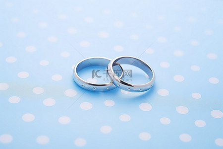 戒指戒指背景图片_爱德华戒指 蓝色正方形表面上的一对匹配的结婚戒指