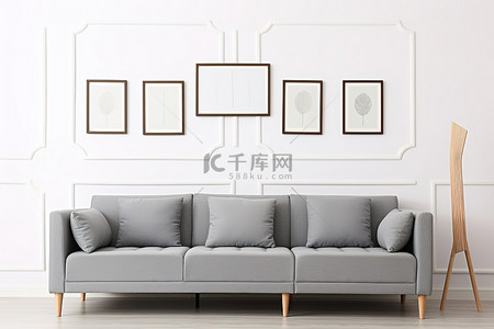 一间带白色沙发的白色房间里的灰色沙发和墙壁相框
