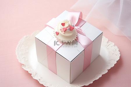 白色盒子里的白色蛋糕，上面系着粉红丝带