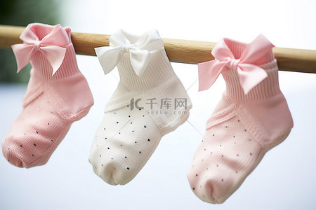 三只背景图片_三只婴儿脚踝袜挂在晾衣绳上，脚上有蝴蝶结