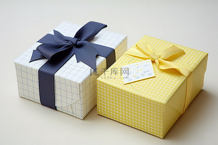 黄色礼物盒子背景图片_一个带有蝴蝶结的礼品盒，另一个带有黄色盒子