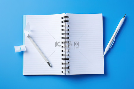 蓝色背景上的空笔记本打开铅笔和卷笔刀