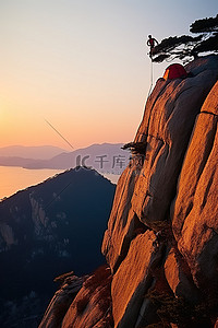 该男子正在爬上悬崖顶，身后有人露营