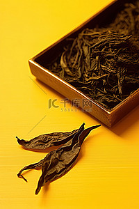 茶叶背景图片_黄色背景上放着一片红茶叶