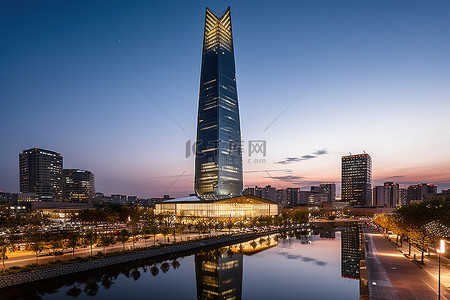 现代世界背景图片_黄昏时分一座方形建筑和一座高塔的图像