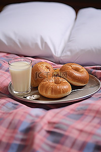 psd床上用品样机背景图片_床上喝了两杯饮料，餐巾之间放着百吉饼和羊角面包
