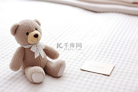 一只泰迪熊坐在白色的桌子上，旁边有一张纸条