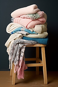 一把木椅，上面有一些折叠的织物和一些彩色的羊毛袜