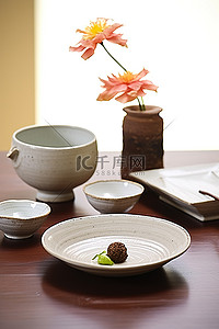 桌面上放着花的碗，桌上放着小盘子