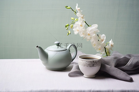 绿色茶壶背景图片_桌上有花的白色和绿色茶壶