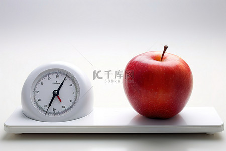 在背景图片_一个红苹果坐在白色的鳞片旁边