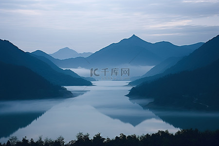 雾蒙蒙的天空中出现了山脉和湖泊的场景