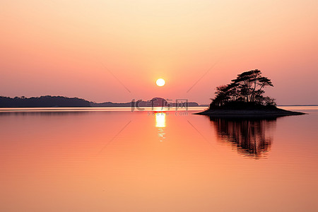 红色的夕阳倒映在水面上，前景是一座岛屿