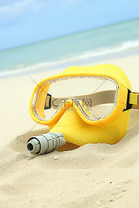 海滩上的黄色潜水面罩通气管和护目镜