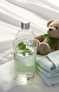 毛巾和泰迪熊旁边的杯子里的水