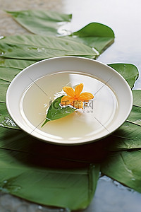 白色花背景图片_橙子汤放在白盘子上，中间有一片叶子