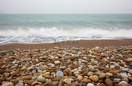 海滨栈道背景图片_布满鹅卵石和海浪的海滨海滩