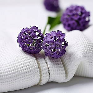 紫色的花朵坐在一些白色的毛巾上