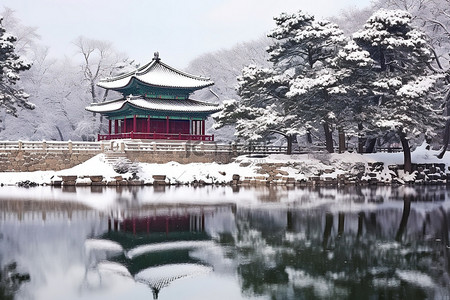 冬天古建筑背景图片_亚洲最古老的宝塔周围被雪覆盖的树木和水