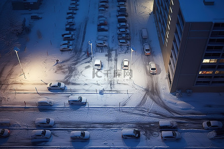 夜晚的雪背景图片_空中拍摄的停车场和街道上的雪