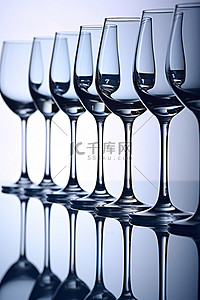 倾倒的酒杯背景图片_酒杯在闪亮的表面上排成一排