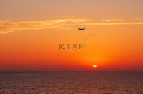 人的剪影背景图片_海洋上空，一架飞机飞过美丽的剪影