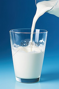 一杯牛奶倒入蓝色背景的玻璃杯中