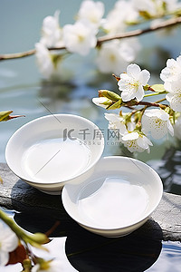 春天背景图片_一碗液体白茶放在春天花朵旁边的盘子上