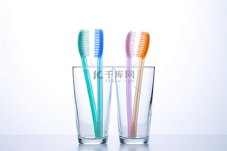 健康卫生背景图片_白色背景中小玻璃杯中的几把牙刷