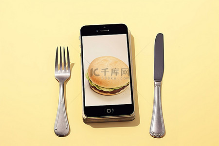 科技iphone背景图片_叉子和勺子旁边放着一部 iPhone