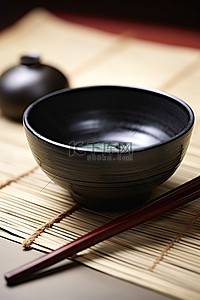 黑色的碗，盘子上有两根筷子