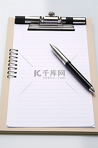 白色剪贴板上的四支笔尖笔和一个空记事本