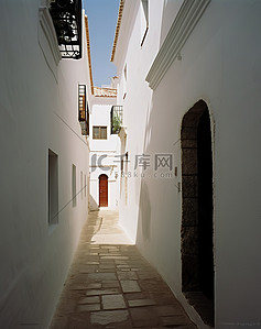 一栋白色墙壁的白色建筑中的一条狭窄通道