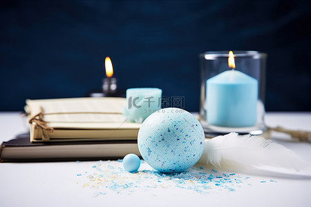 一张桌子，上面有一个蓝色的鸡蛋一本书和一支蜡烛
