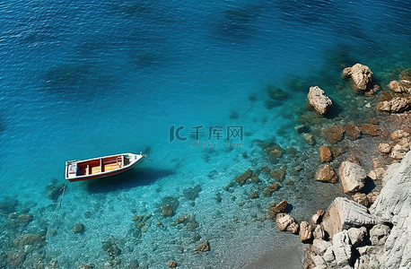 一艘蓝色的船停在岩石海岸上，坐在船甲板上