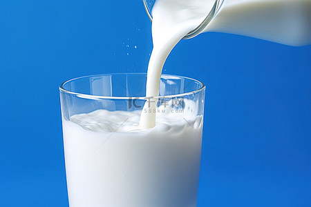 蓝色牛奶背景背景图片_蓝色背景中牛奶被倒入一杯水中