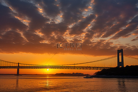 寒假旅行记背景图片_日落时，一座桥背后有太阳