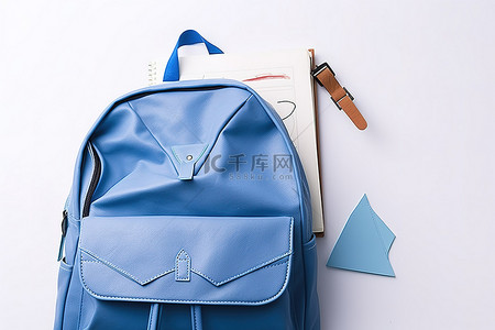 一个蓝色背包，里面有纸笔记本纸和剪刀