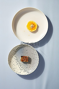 两个盘子，上面有两片水果一个煎鸡蛋和一个煎蛤
