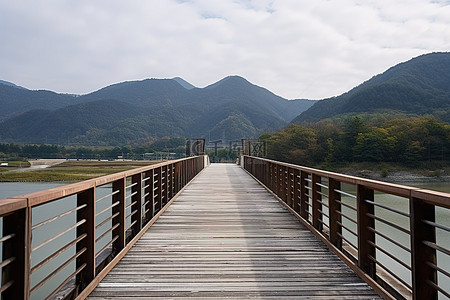 水里背景图片_一座木桥通向空旷山谷中的山脉