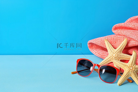夏天海星背景图片_蓝色背景中的人字拖和毛巾，配有草莓太阳镜和海星