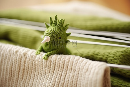 毛衣上有一个绿色的针织玩具