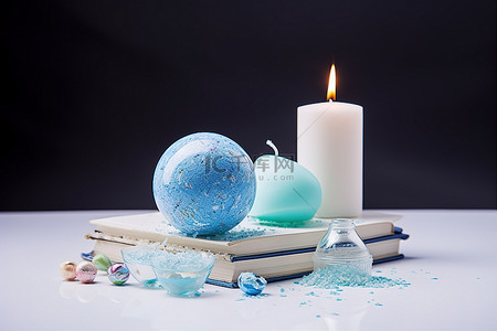浴背景图片_一张桌子，上面有一个蓝色的鸡蛋一本书和一支蜡烛