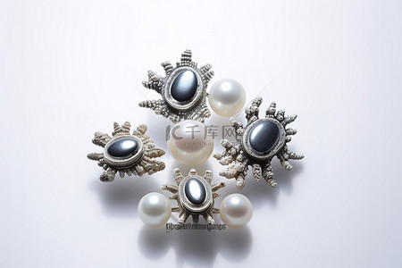 四个黑色圆环和珍珠位于一些贝壳的顶部