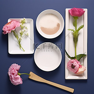 三个白盘子，上面有不同的花，一把铲子和一朵花